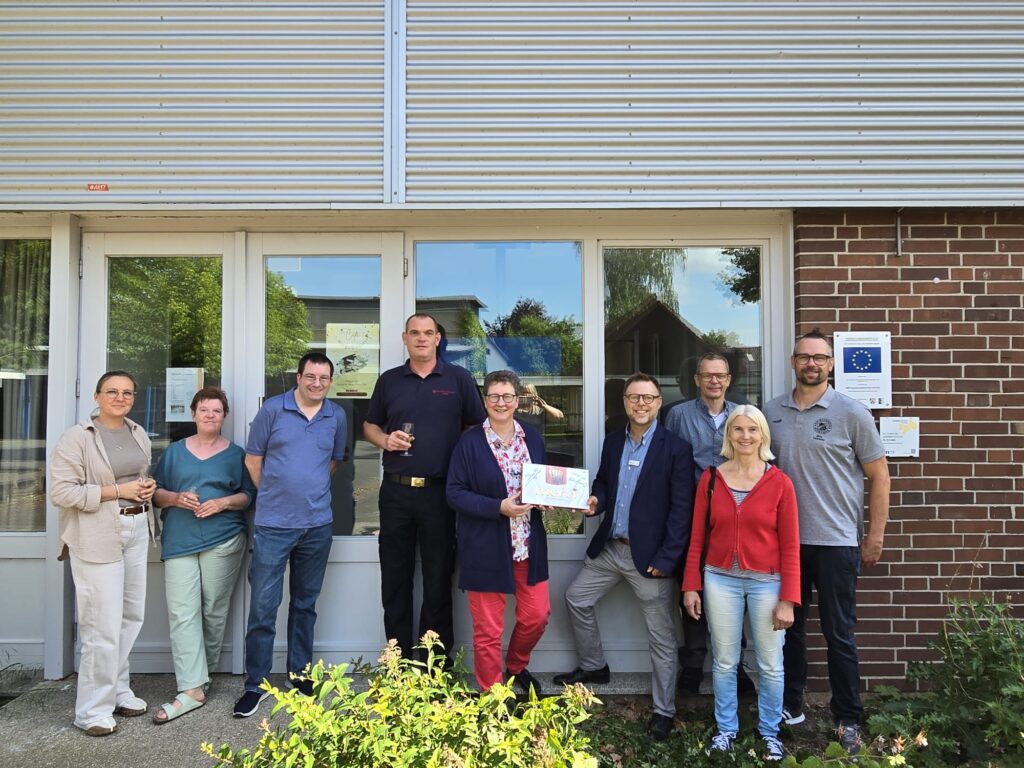 Foto: (von links nach rechts) Anne-Marie Lange, Sabine Soltau (Café MitgeDACHt, Das Dach e.V.), Alexander Bertram (Mitglied im Ortsausschuss Hörstmar), Andreas Liese (Freiwillige Feuerwehr Lemgo), Dr. Angelika Heil (Stiftung Standortsicherung, Kreis Lippe), Hendric Schwär-Fröhlich (Stadt Lemgo), Ralf Wegner (Stadt Lemgo), Beate Kelle (Kita Hörstmar) und Nils Lessow (SV Hörstmar 1928 e.V.).